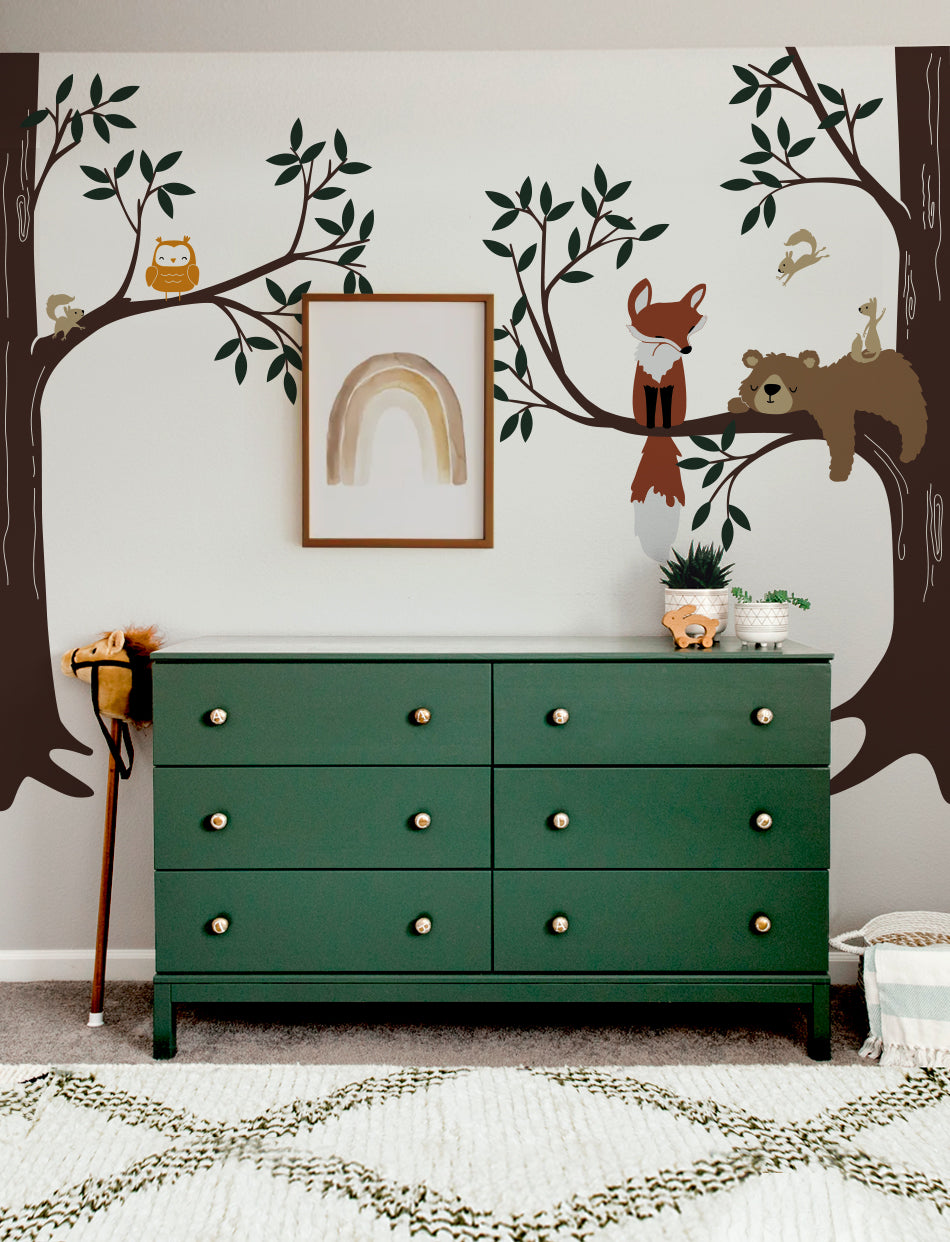 A wall decal featuring a bear, fox, owl, and squirrels in a woodland setting | www.pinknbluebaby.com